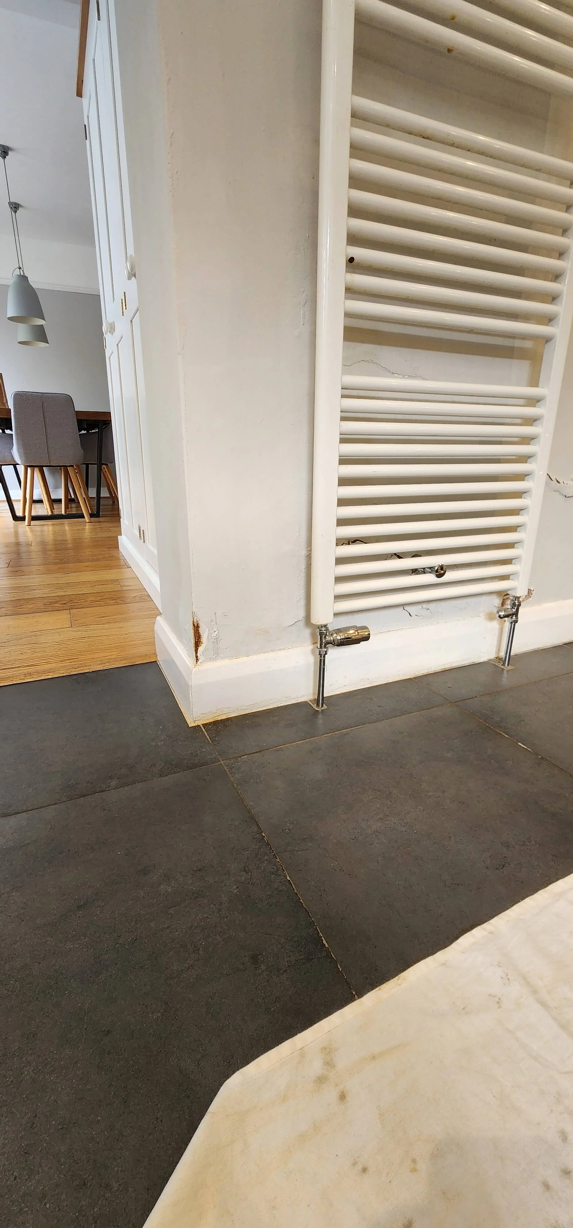 Wall staining beside radiator pipework during Betchworth leak investigation