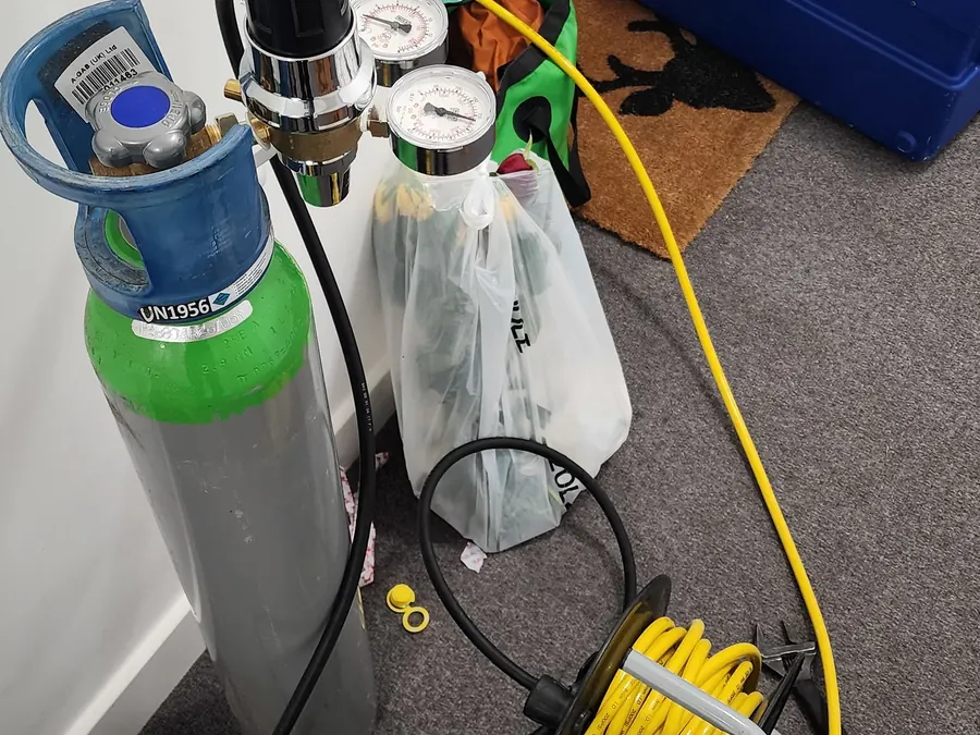 Tracer gas cylinder, pressure gauges and test hose used during the Brighton bathroom investigation