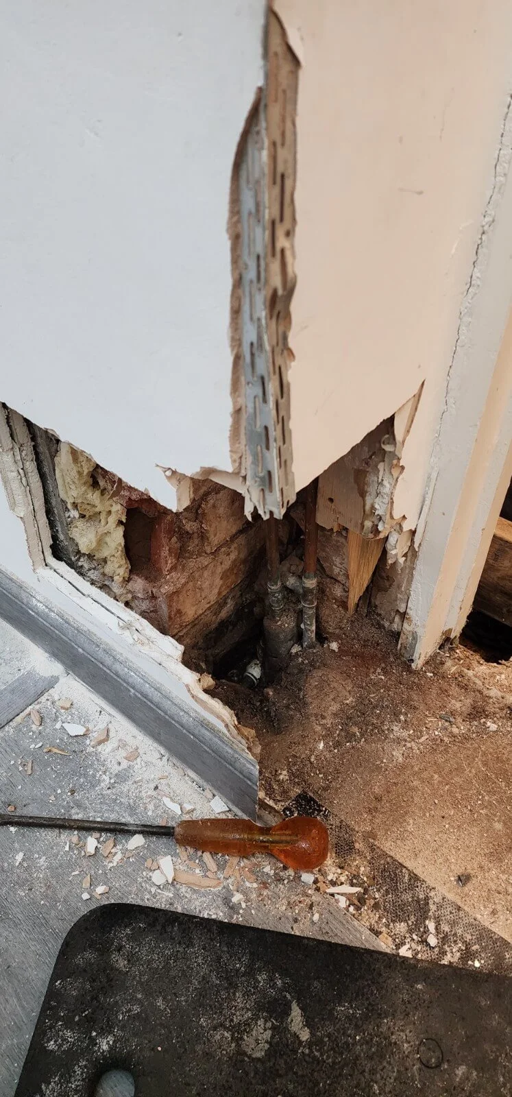 Access opening around pipework during mains water leak detection in Coventry