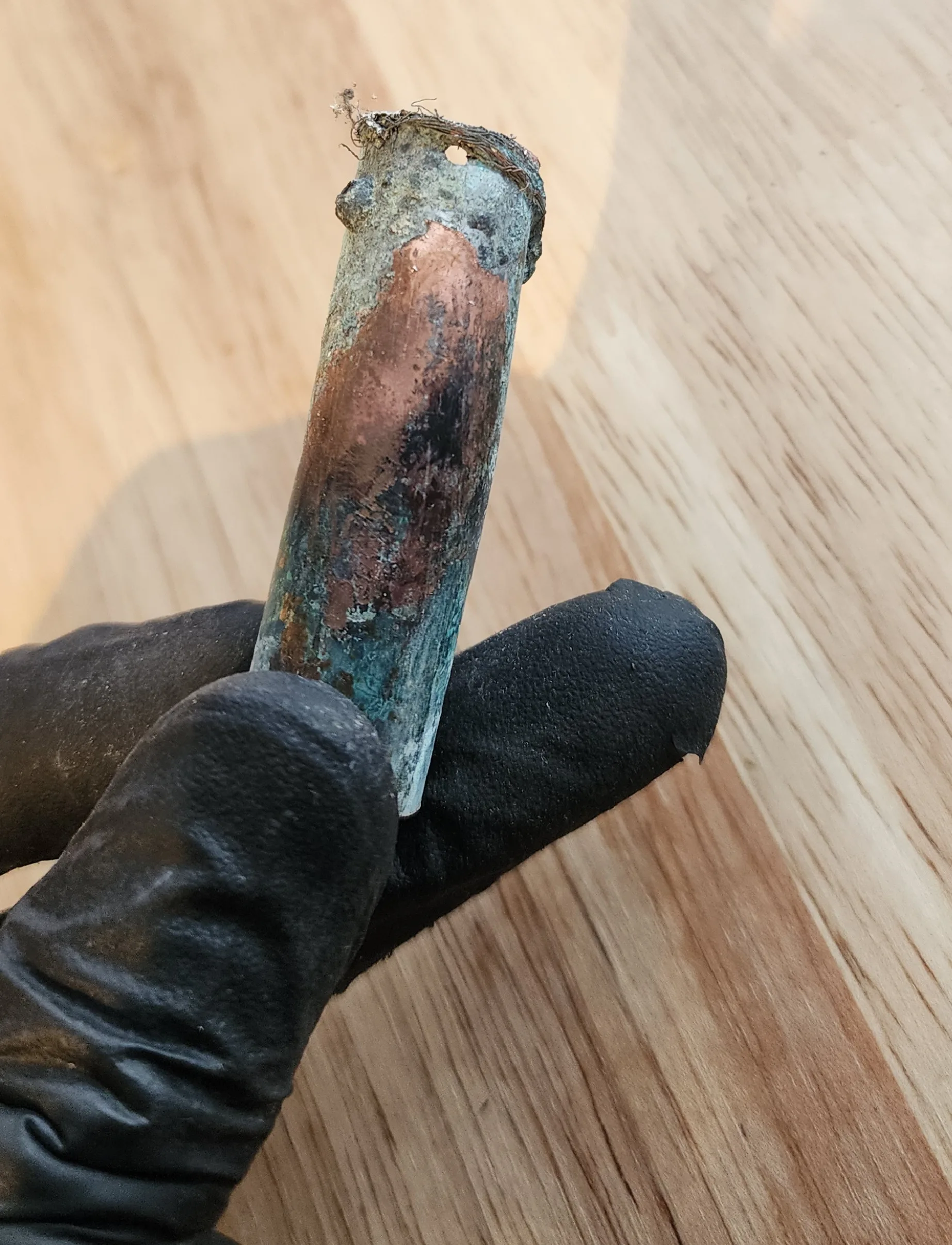 Removed copper mains pipe section with a small pinhole near its cut end