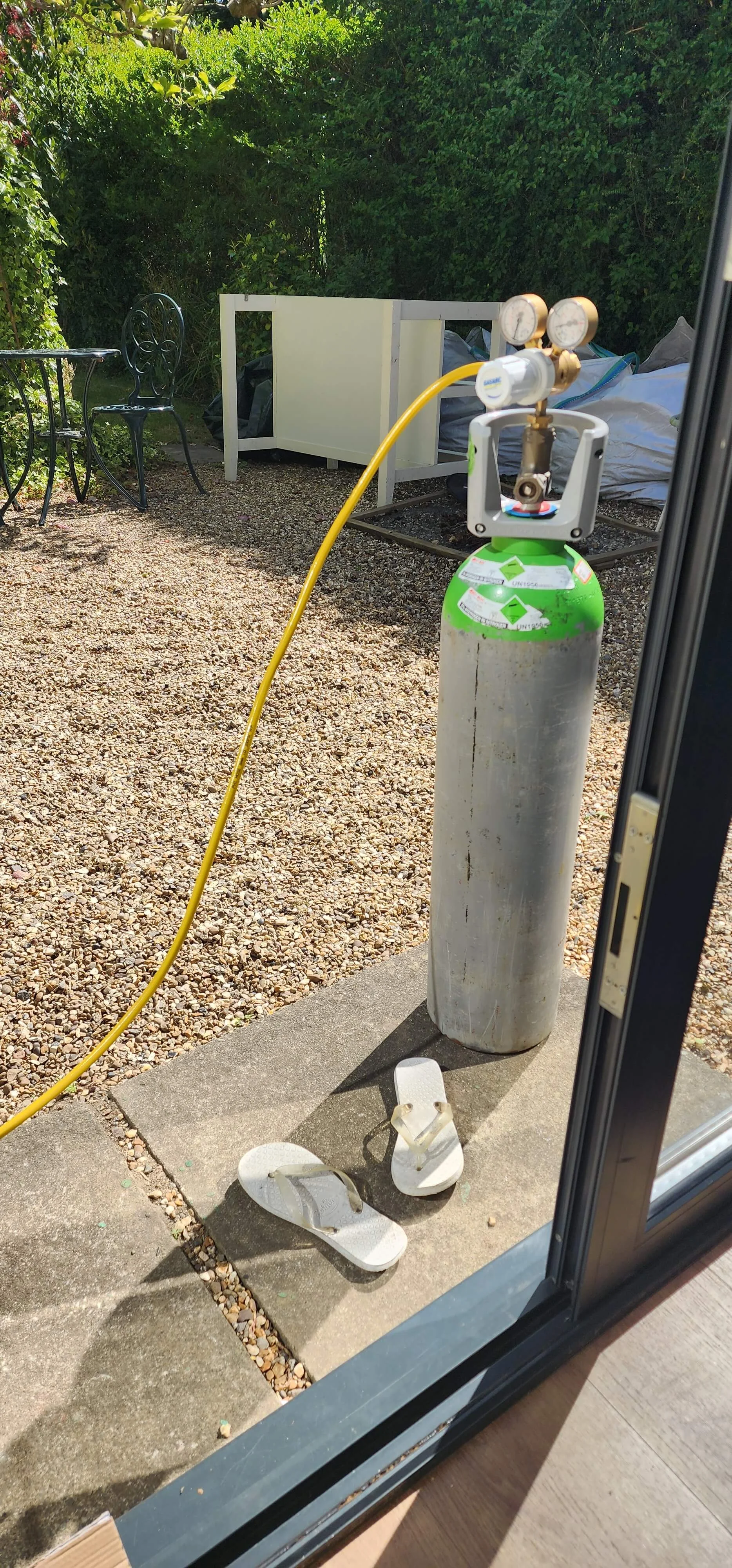 Tracer gas cylinder connected during central heating leak detection in Farnham