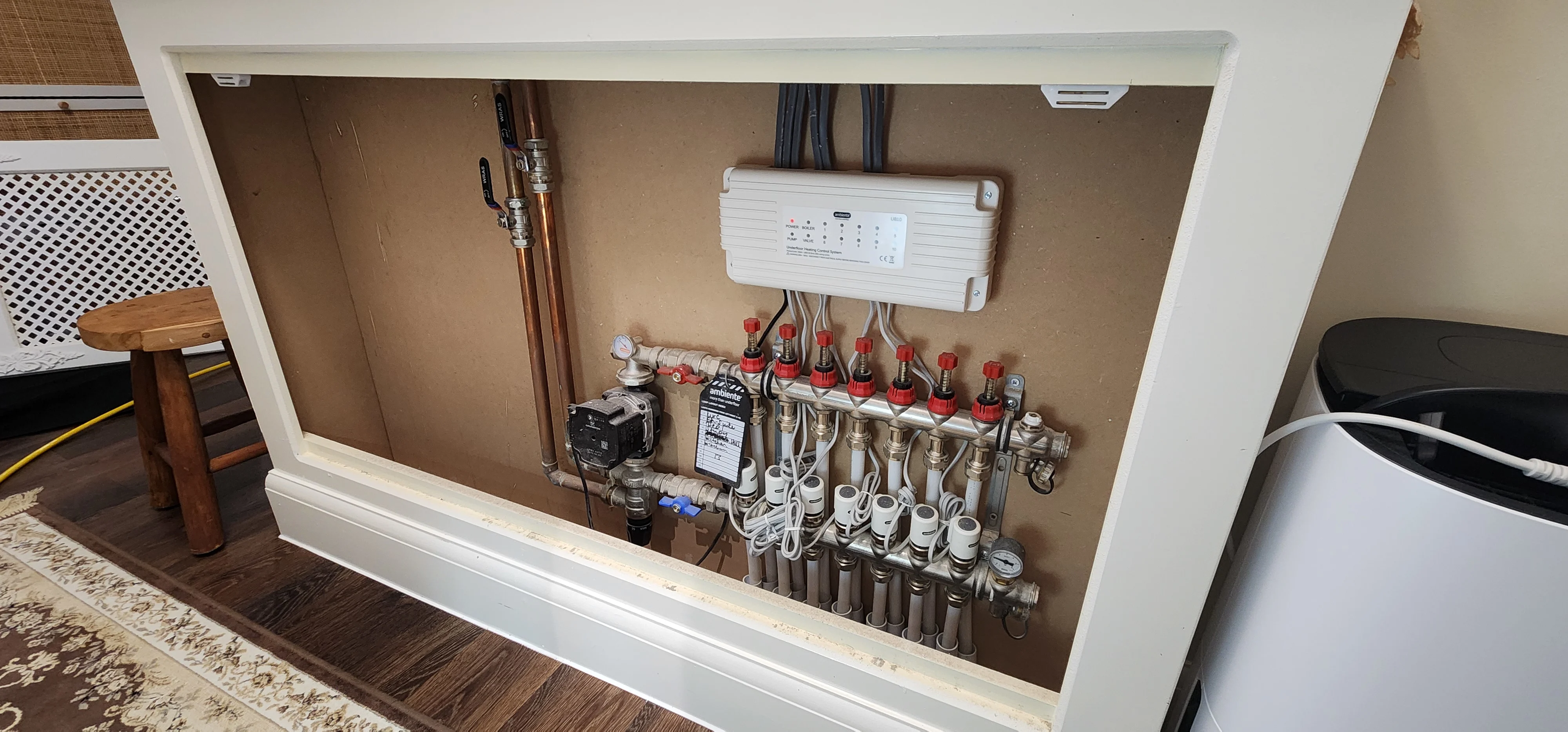Heating manifold, circulation pump and controls exposed for plumbing circuit testing