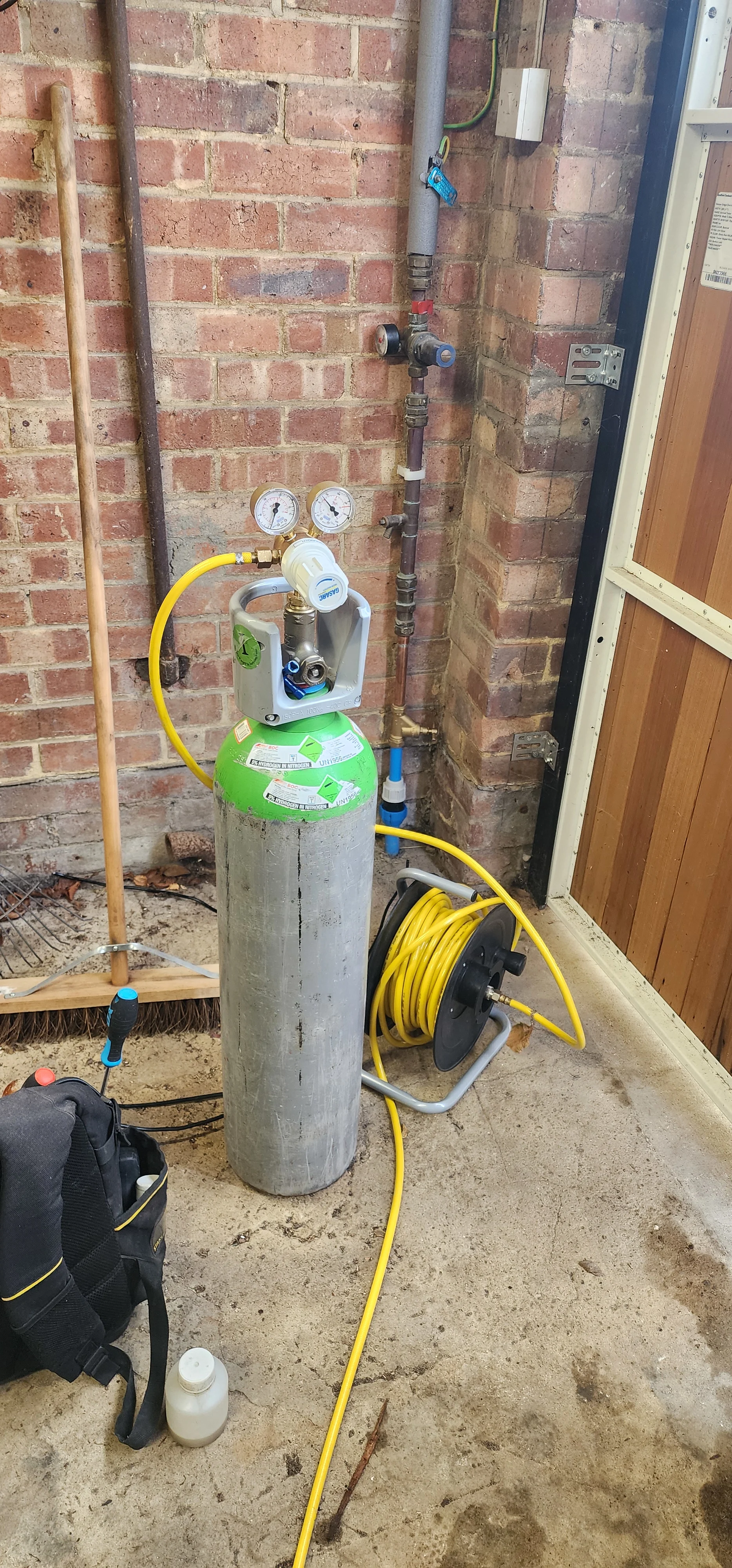 Tracer gas cylinder connected to pipework during mains water leak detection in Kingston