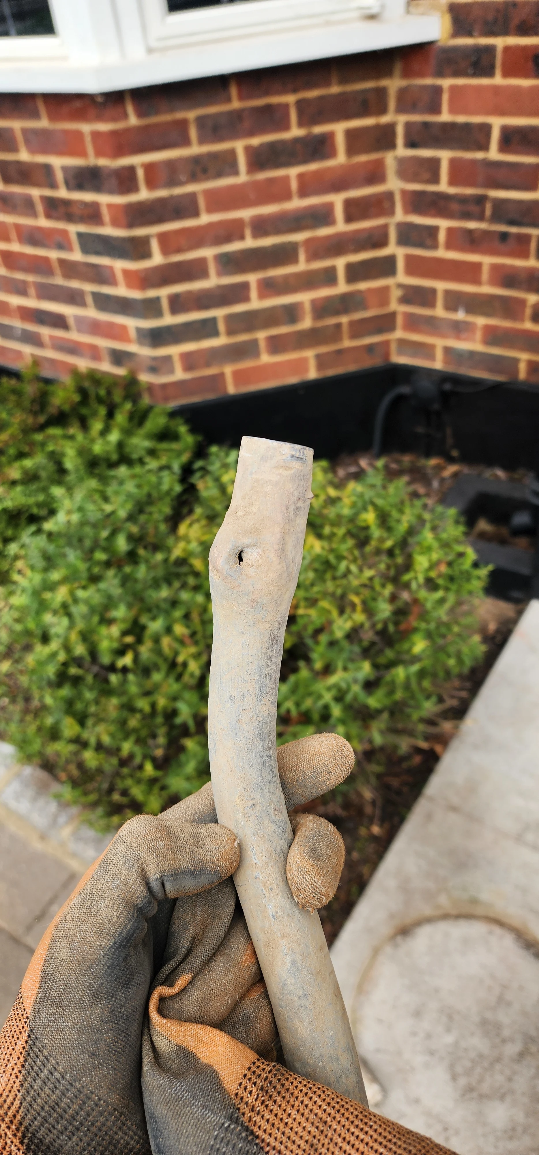 Removed lead supply pipe section showing a leak hole in Kingston
