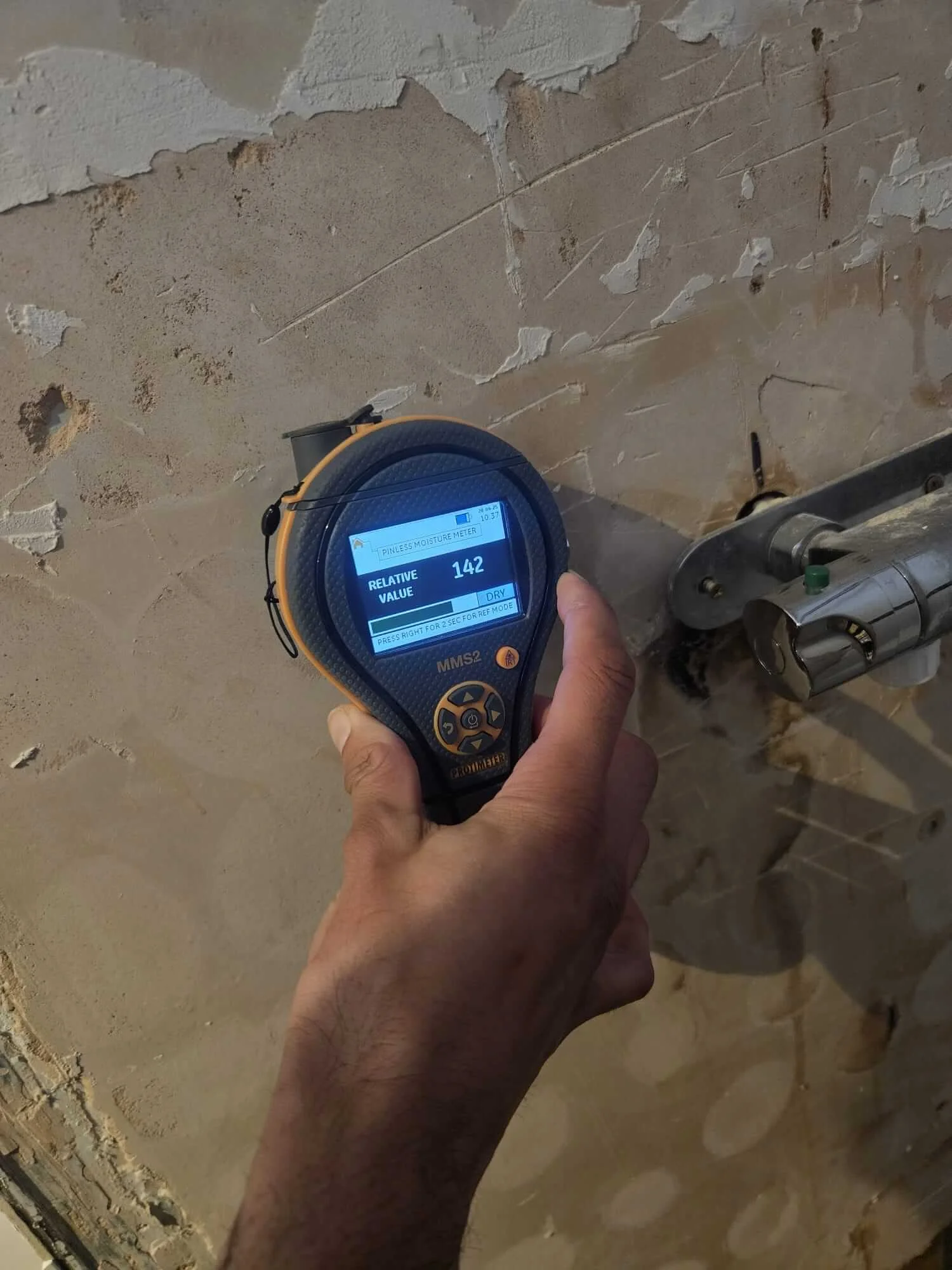 Moisture meter reading around shower wall during Kingston leak investigation