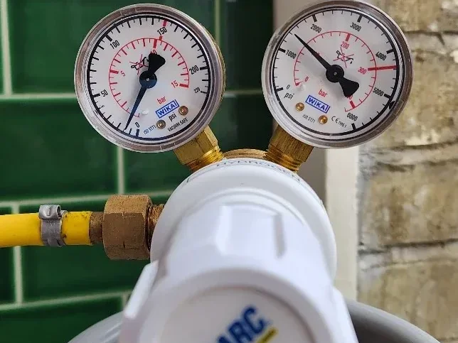Tracer gas regulator connected during central heating leak detection