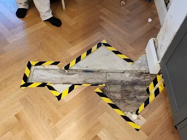 Opened floor area showing access evidence during concealed leak investigation